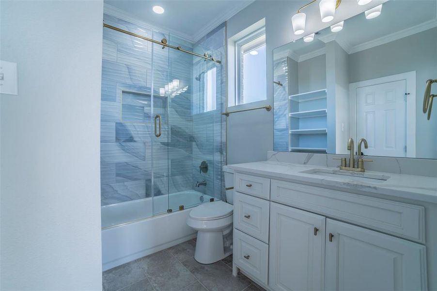Bathroom featuring vanity, crown molding, combined bath / shower with glass door, and light tile patterned flooring Bathroom featuring vanity, crown molding, combined bath / shower with glass door, and light tile patterned flooring