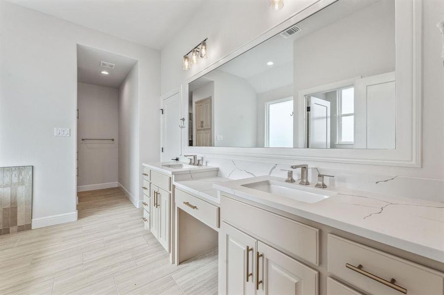 Full bath with double vanity and baseboards
