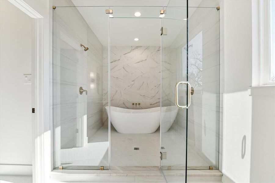 Dramatic and beautiful wet room featuring double shower heads and soaking tub.