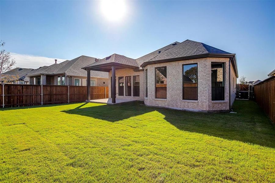 Rear view of property with a patio area and a lawn