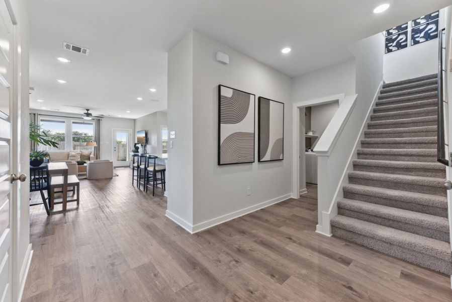 A room with a wood floor and a wood staircase. A room with a wood floor and a wood staircase.