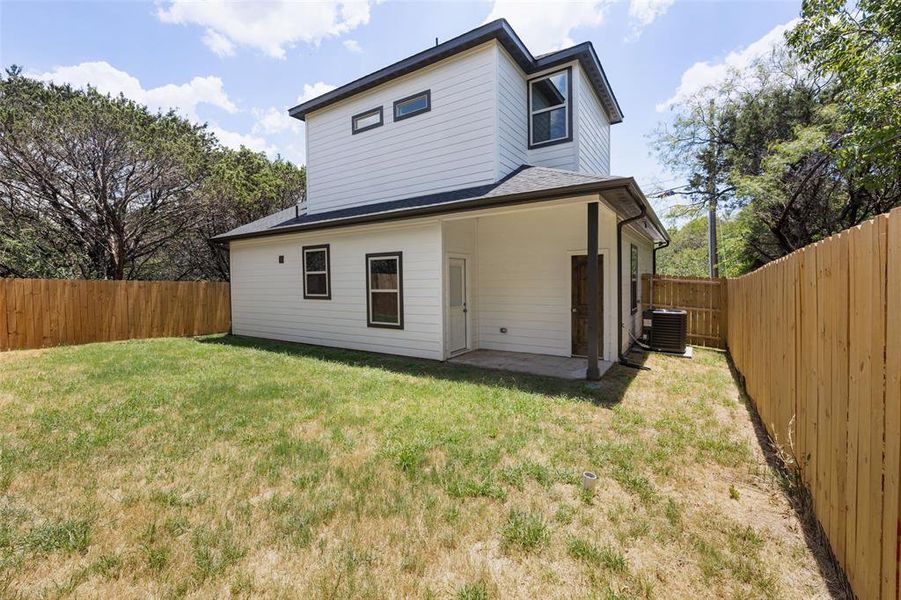 Rear view of property with a patio, a lawn, and central AC unit