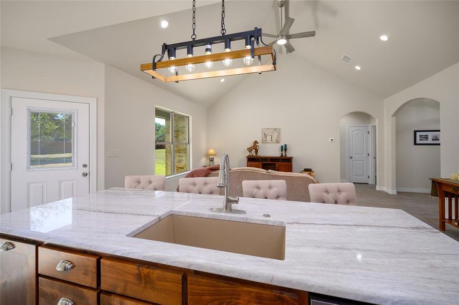 Kitchen with ceiling fan, sink, hanging light fixtures, and a wealth of natural light