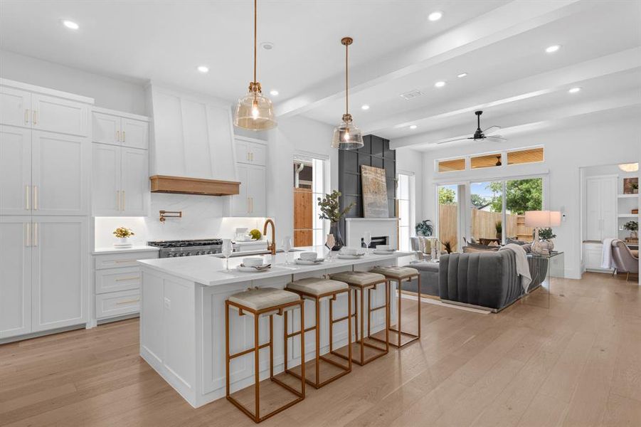 Kitchen featuring open floor plan, a farm sink with additional features, recessed lighting, light hardwood oak flooring, beamed ceiling and electric blinds throughout entire home. Kitchen featuring open floor plan, a farm sink with additional features, recessed lighting, light hardwood oak flooring, beamed ceiling and electric blinds throughout entire home.