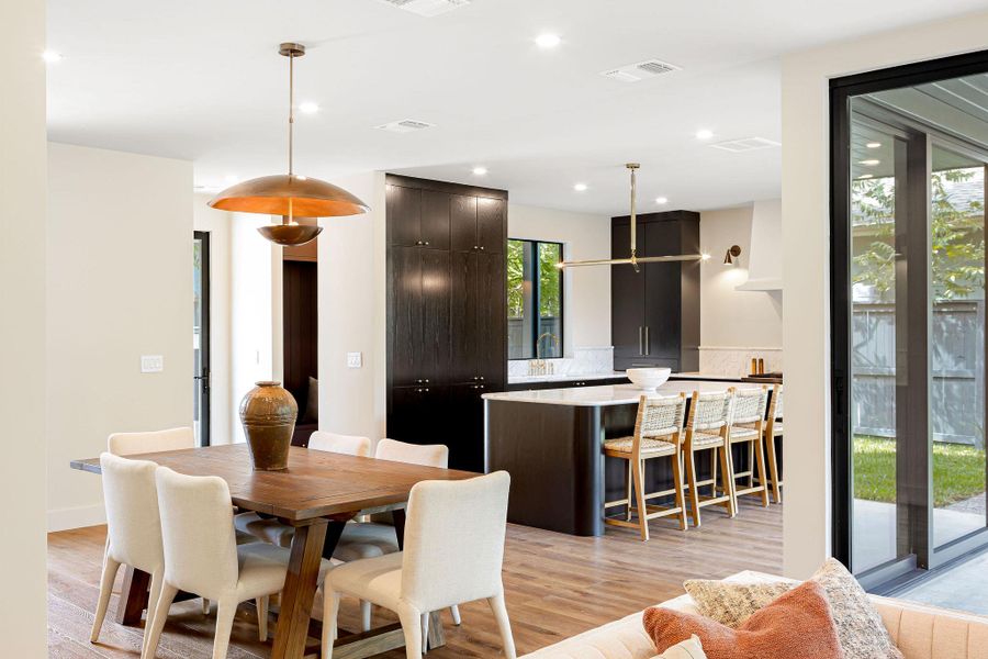 Dining room with light wood-type flooring and recessed lighting