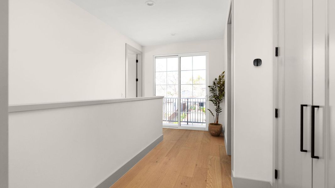 Hall featuring light wood finished floors and baseboards