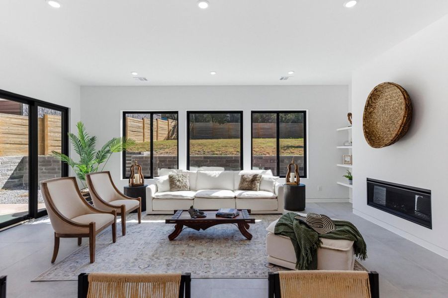 Living area featuring healthy amount of natural light, recessed lighting, and a glass covered fireplace