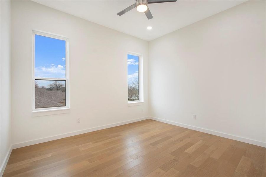 Unfurnished room with light hardwood / wood-style floors and ceiling fan