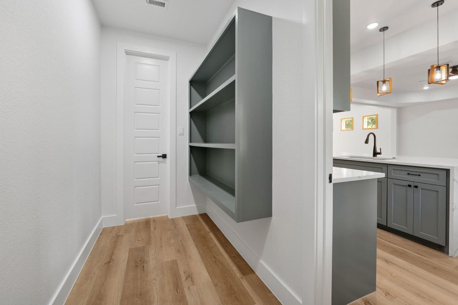 Expansive walk-in pantry featuring sleek custom shelving for optimal organization. Expansive walk-in pantry featuring sleek custom shelving for optimal organization.