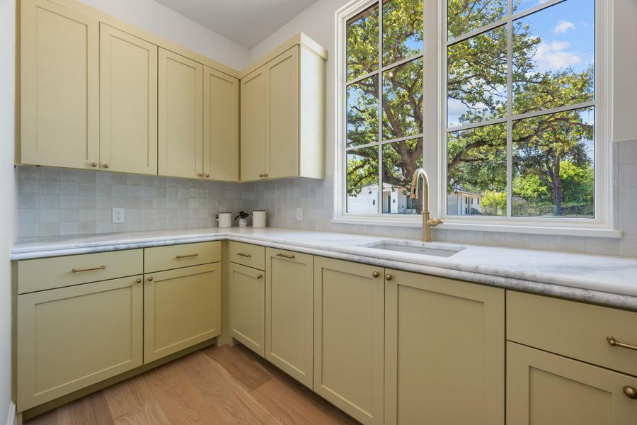 A wall of custom cabinetry lines the prep space beneath a large multi-pane window.