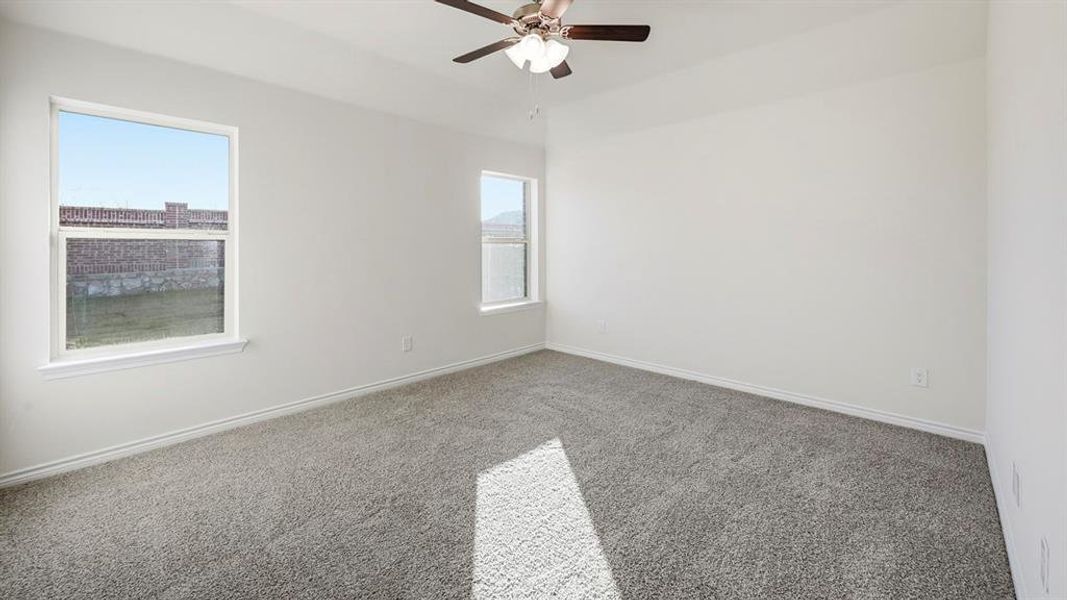 Spacious room featuring light gray carpeting, neutral white walls, and two windows providing natural light