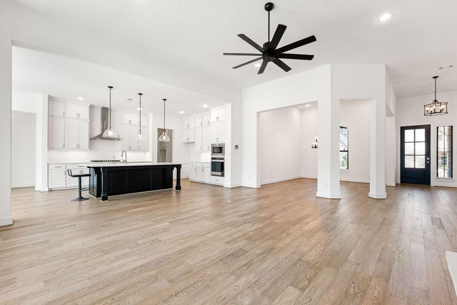 Gather the family and guests together in your lovely living room! Featuring high ceilings, recessed lighting, dark stained ceiling fan, custom paint, gorgeous floors, and large windows that provide plenty of natural lighting throughout the day!