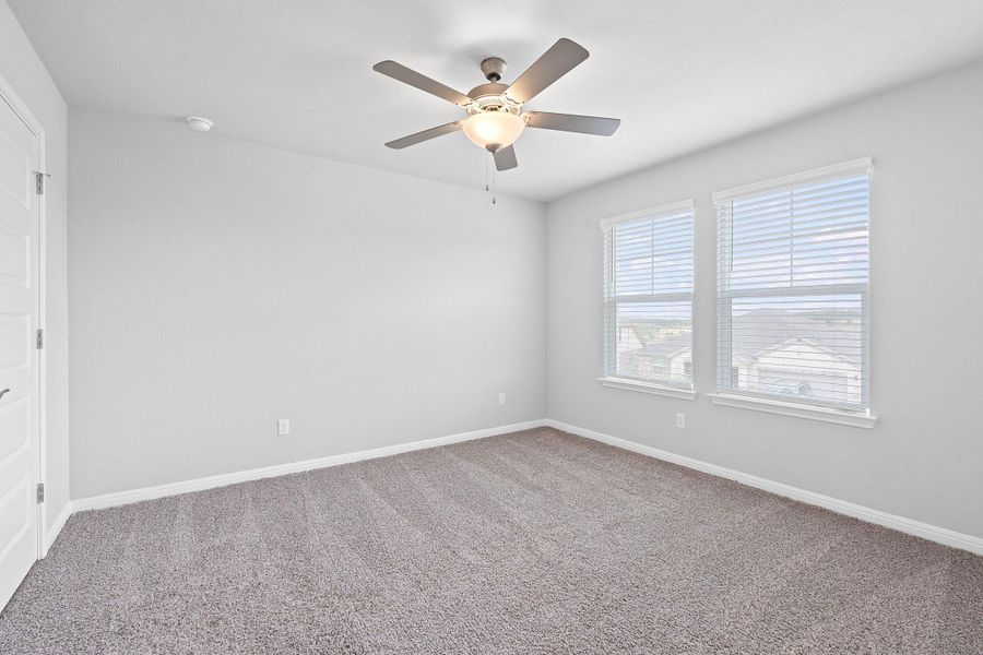 Carpeted empty room featuring a ceiling fan and baseboards Carpeted empty room featuring a ceiling fan and baseboards