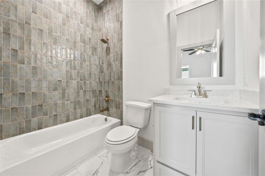 Bathroom with tub / shower combination, vanity, ceiling fan, and light marble finish flooring