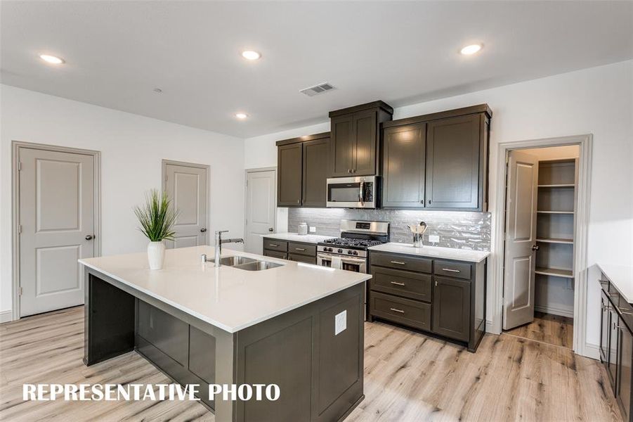 The large kitchen island makes the perfect gathering place for family and friends!  REPRESENTATIVE PHOTO.