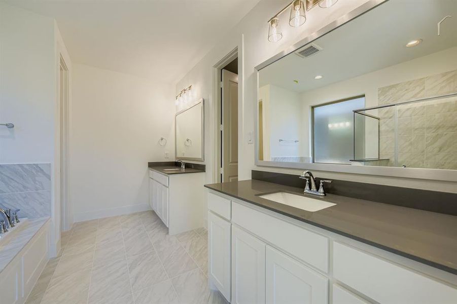 Bathroom featuring two vanities, a bath, light tile patterned floors, and tiled shower Bathroom featuring two vanities, a bath, light tile patterned floors, and tiled shower