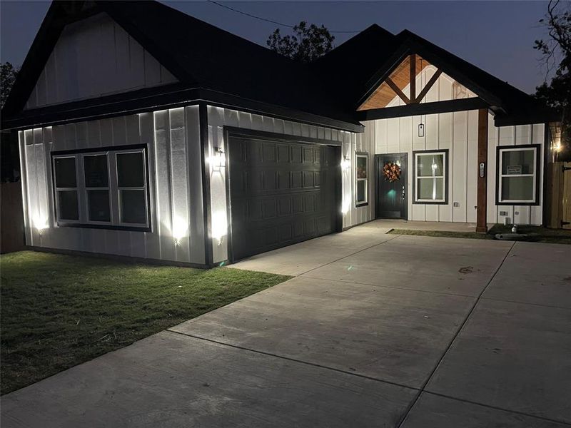 View of front of home with a garage and a front lawn