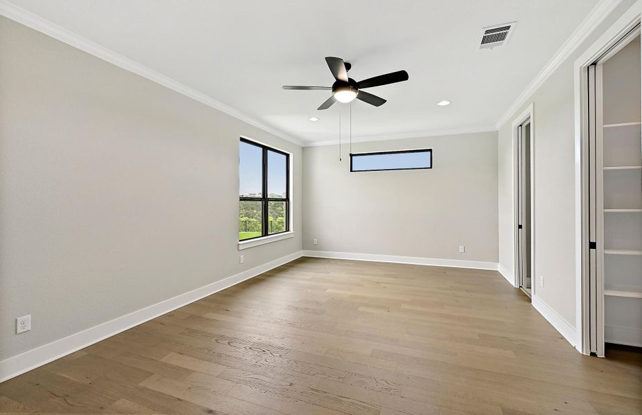 Hardwood floors and a ceiling fan complete this airy, north facing bedroom. There is an en-suite and very large walk-in closet.