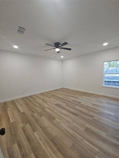 Unfurnished room featuring visible vents, baseboards, a ceiling fan, and light wood finished floors