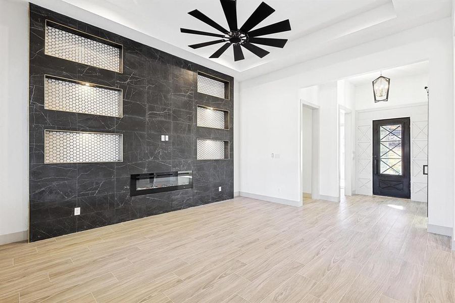 Foyer featuring a raised ceiling and ceiling fan