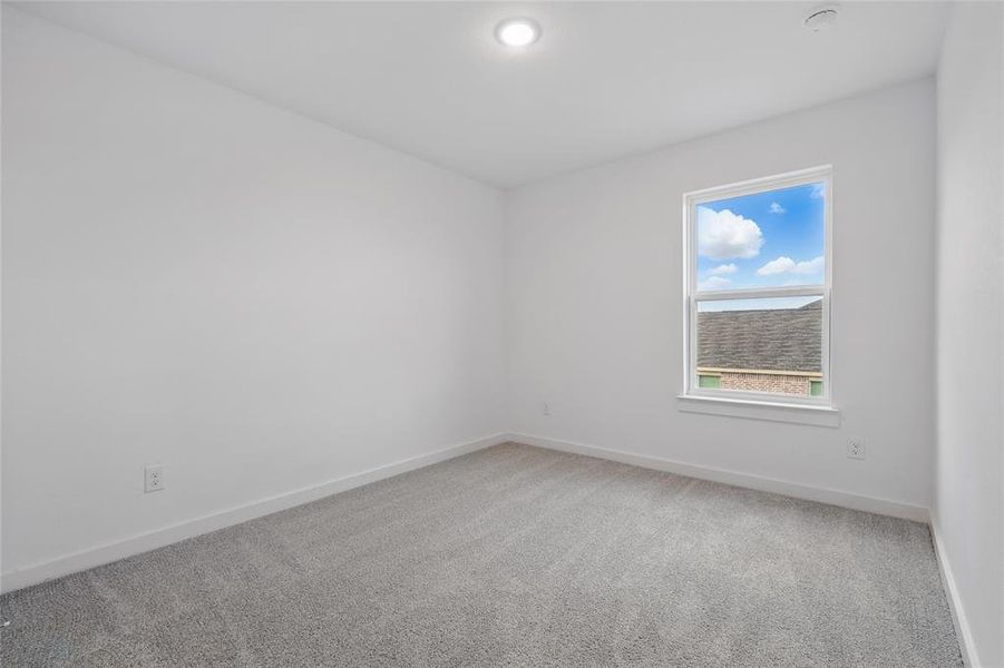 Unfurnished room featuring light carpet and baseboards