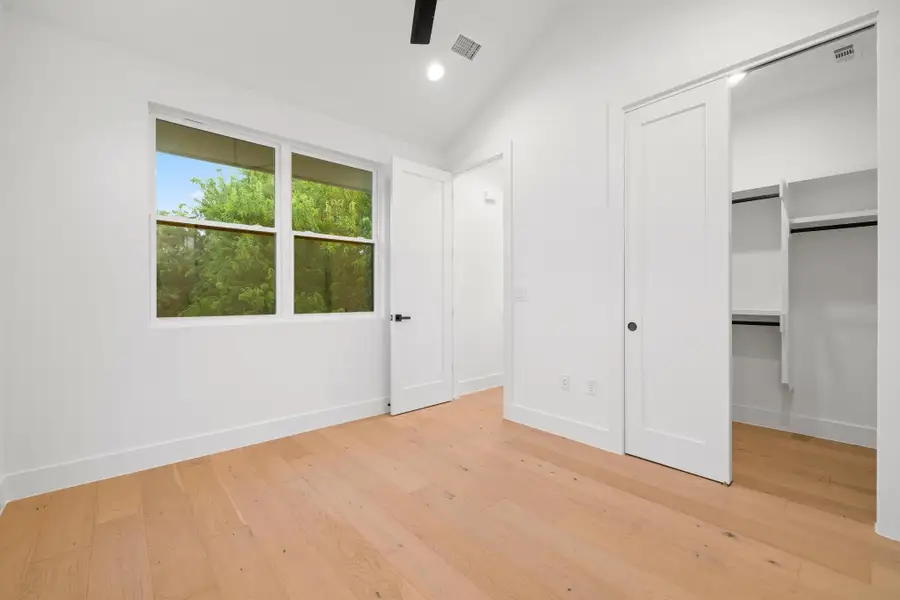 Unfurnished bedroom with light wood-style flooring, vaulted ceiling, recessed lighting, and a closet Unfurnished bedroom with light wood-style flooring, vaulted ceiling, recessed lighting, and a closet