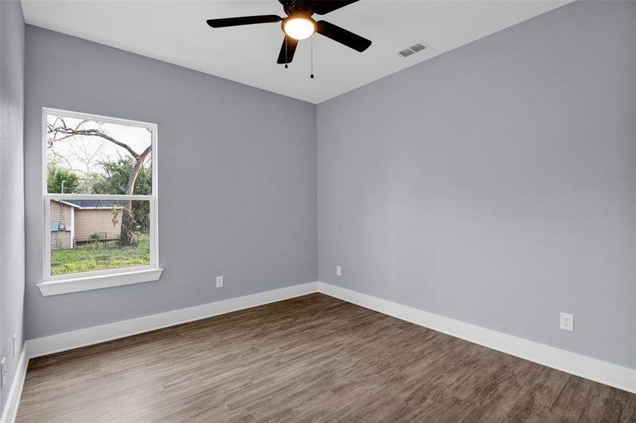 Spare room featuring dark wood-style floors and ceiling fan
