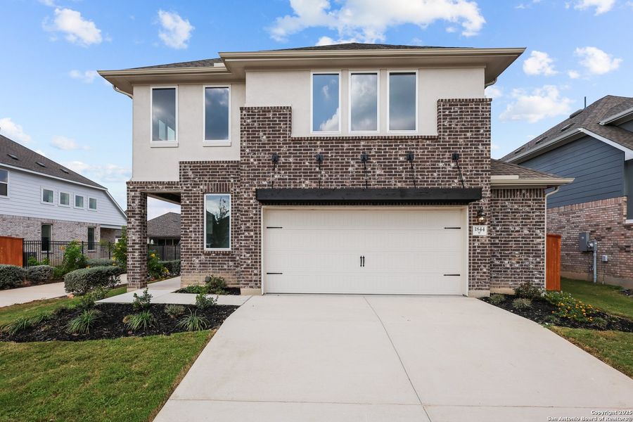 Front exterior of a new home in Veramendi, New Braunfels, TX, highlighting curb appeal (Image 1).