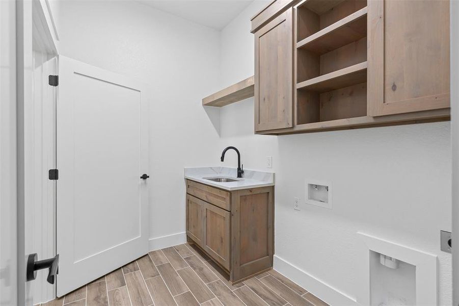 Laundry room with wood finish floors, washer hookup, hookup for an electric dryer, and cabinet space Laundry room with wood finish floors, washer hookup, hookup for an electric dryer, and cabinet space