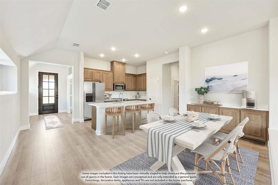 Open-plan dining area and kitchen with white island, wood cabinets, and light hardwood floors Open-plan dining area and kitchen with white island, wood cabinets, and light hardwood floors