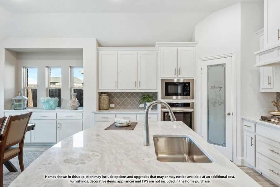Kitchen with white cabinets, marble island, stainless steel appliances, and a frosted glass pantry door. Kitchen with white cabinets, marble island, stainless steel appliances, and a frosted glass pantry door.