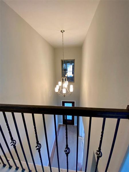 View of entry from upstairs with beautiful chandelier