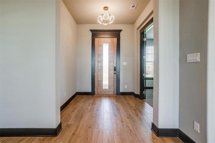 Foyer entrance featuring a chandelier and light hardwood / wood-style flooring