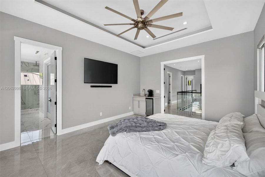 Primary bedroom suite w/ french doors, morning bar, en suite walk in closet and spa bathroom. Sliders lead to private balcony looking down the river