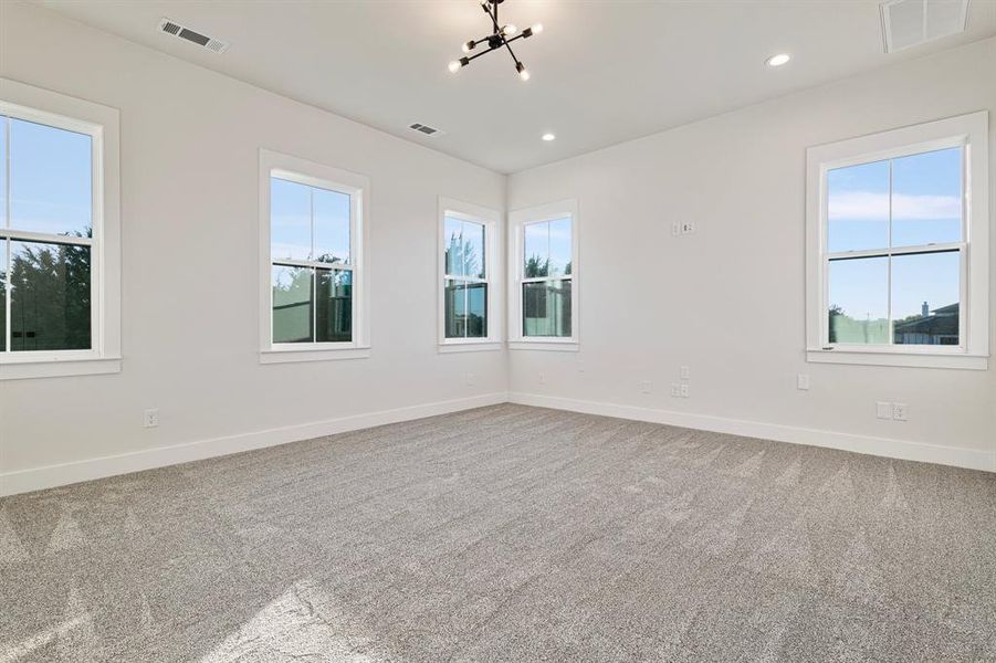 Carpeted spare room with a chandelier