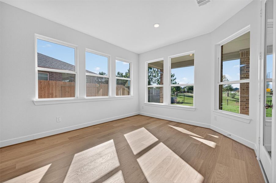 Bright and inviting, this breakfast area is surrounded by windows that fill the space with natural light and offer peaceful views of the backyard. It’s the perfect spot to start your morning or enjoy a cozy meal with family.The primary bedroom is filled with natural light and offers peaceful views through large windows. Its open layout and warm flooring create a relaxing retreat.
