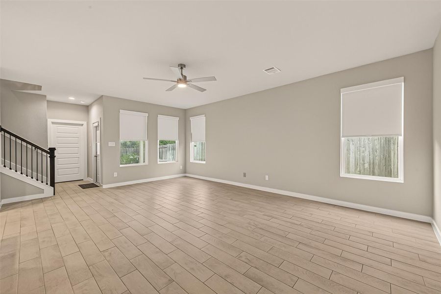 These three spaces feature tile flooring, and large windows overlooking the backyard bring in plenty of natural light, creating a bright and comfortable setting.