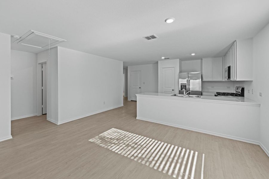 Kitchen featuring a peninsula, white cabinetry, light countertops, stainless steel appliances, and light wood-style floors Kitchen featuring a peninsula, white cabinetry, light countertops, stainless steel appliances, and light wood-style floors