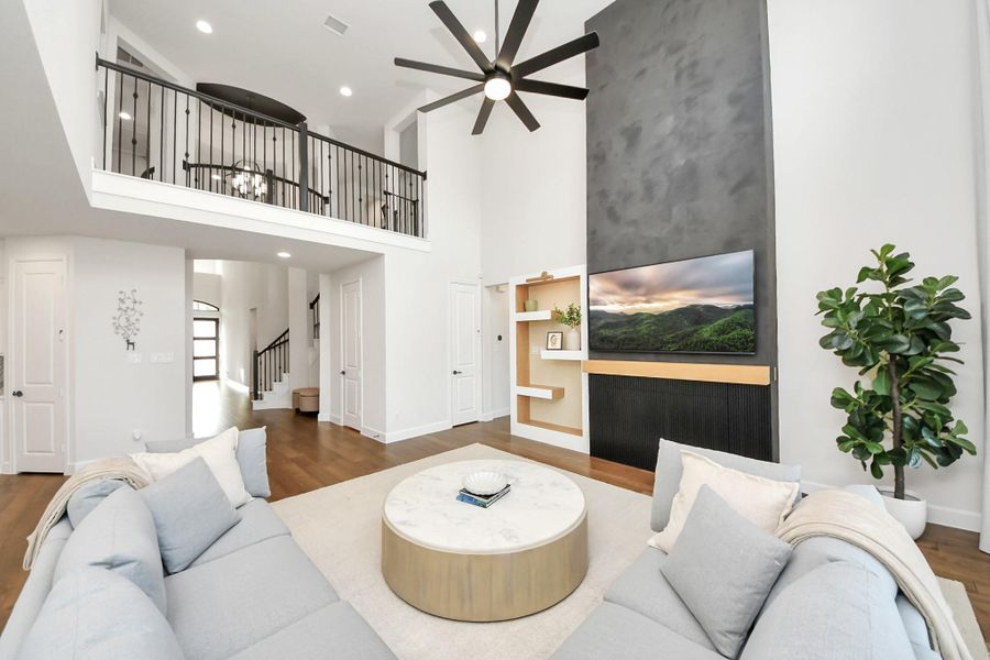 Two-story living area with upstairs overlook and elegant lighting