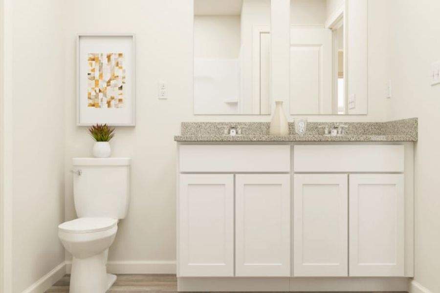 A bathroom with white cabinets.