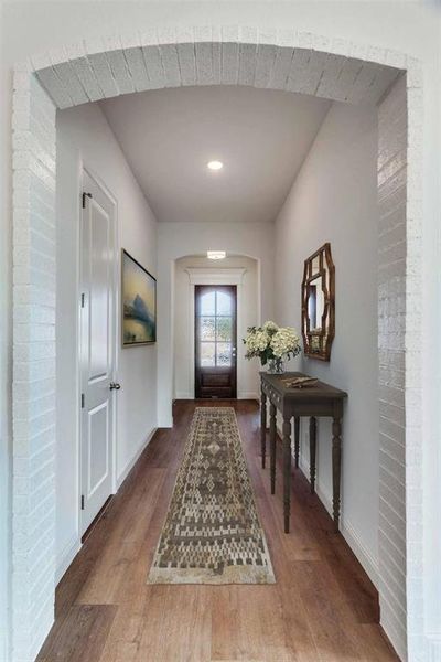 Foyer entrance with wood finished floors and arched walkways