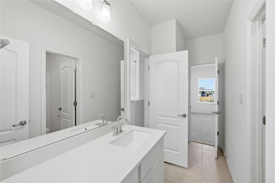 Bathroom featuring light tile patterned flooring, vanity, and light colored carpet Bathroom featuring light tile patterned flooring, vanity, and light colored carpet