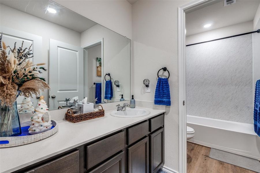Full bathroom with vanity, light wood finished floors, and bathtub / shower combination Full bathroom with vanity, light wood finished floors, and bathtub / shower combination