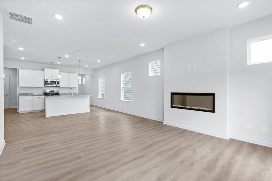 The Dove- Family Room into the Kitchen. Home under construction, photo used for illustrative purposes only, colors and options will vary.