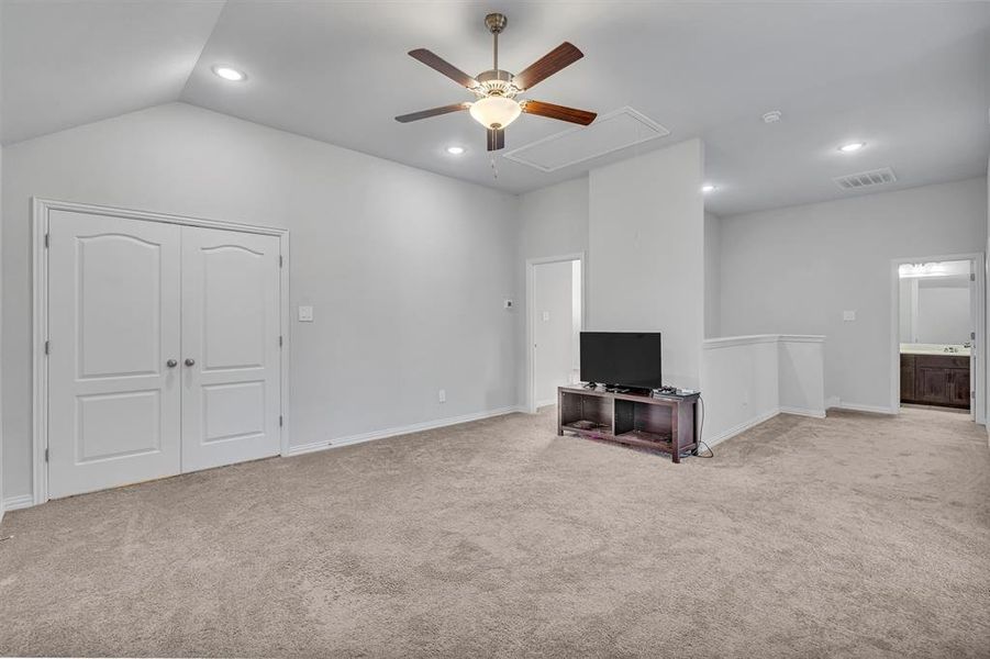 Unfurnished living room with ceiling fan, lofted ceiling, and light colored carpet