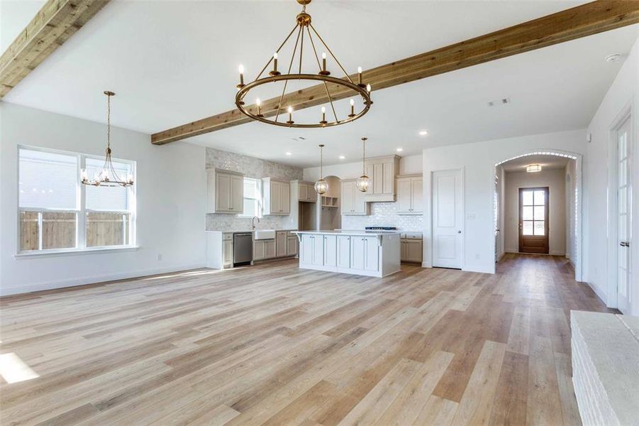 Kitchen with hanging light fixtures, beam ceiling, a center island, a notable chandelier, and stainless steel dishwasher