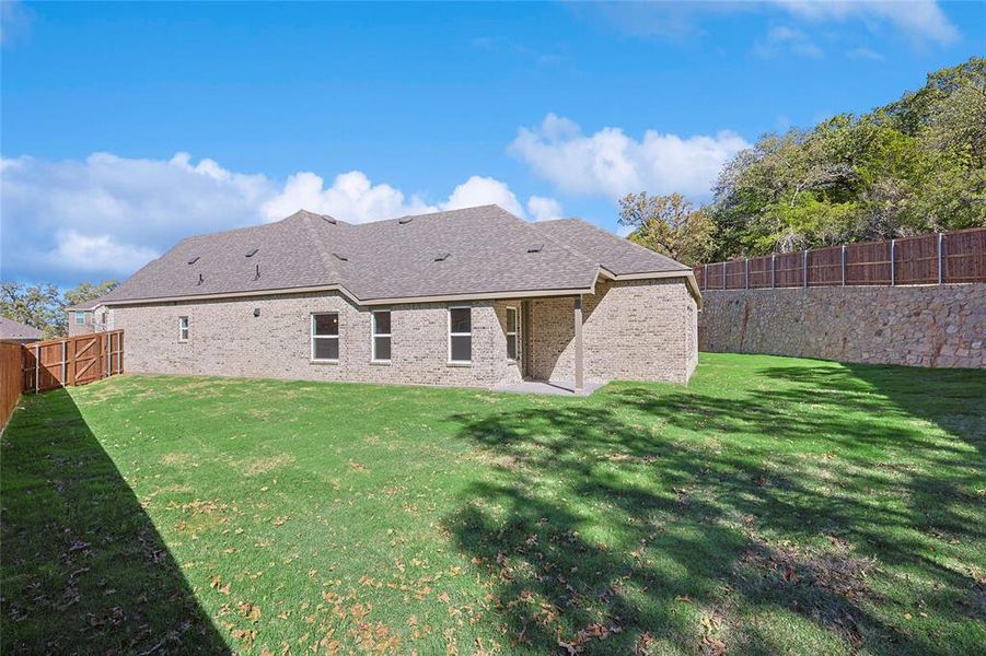 Rear view of property with a yard