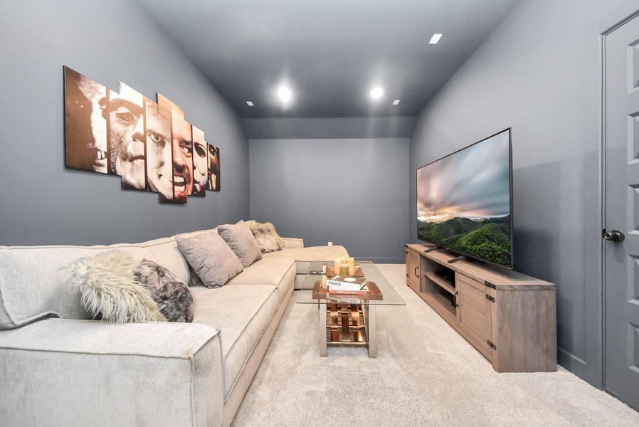 Spacious theatre room upstairs featuring a dark, cinema-style ambiance.