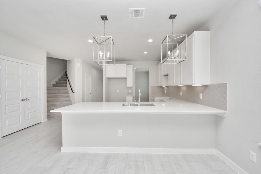 The extended counter area adds both practicality and style, making meal preparation a breeze. Every detail is thoughtfully designed to enhance the kitchen's functionality and aesthetic appeal. Sample photo of completed home with similar floor plan. Actual colors and selections may vary. The extended counter area adds both practicality and style, making meal preparation a breeze. Every detail is thoughtfully designed to enhance the kitchen's functionality and aesthetic appeal. Sample photo of completed home with similar floor plan. Actual colors and selections may vary.