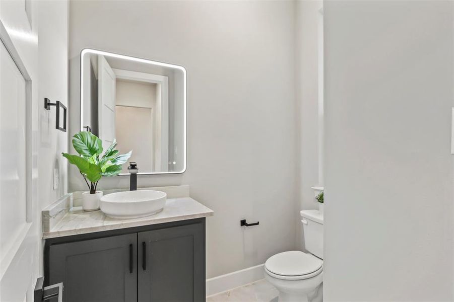 Half bathroom featuring vanity and toilet Half bathroom featuring vanity and toilet